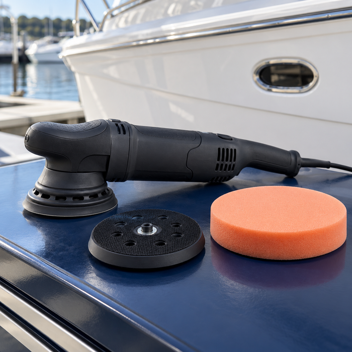 Boat polisher with a separate hook-and-loop backing plate and orange foam polishing pad on a marine workshop bench.