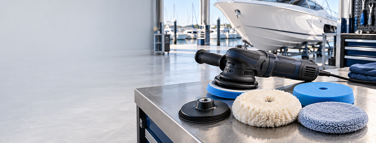 Boat polisher, buffing pads and backing plate on a marine workshop bench with white space on the left.