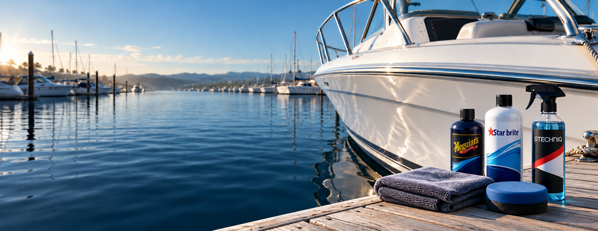Meguiar’s, Star brite and Gtechniq branded bottles with detailing accessories beside a white boat hull at a marina.