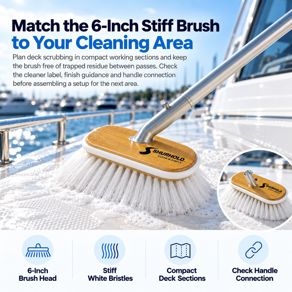 Shurhold 950 6-inch stiff deck brush with white bristles and a wooden head scrubbing a soapy yacht deck.